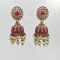 Pair of ornate earrings with pink gemstones and pearl drops on a white background