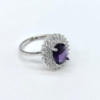 Silver ring with a purple gemstone on a white background