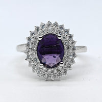 Silver ring with a purple gemstone on a white background