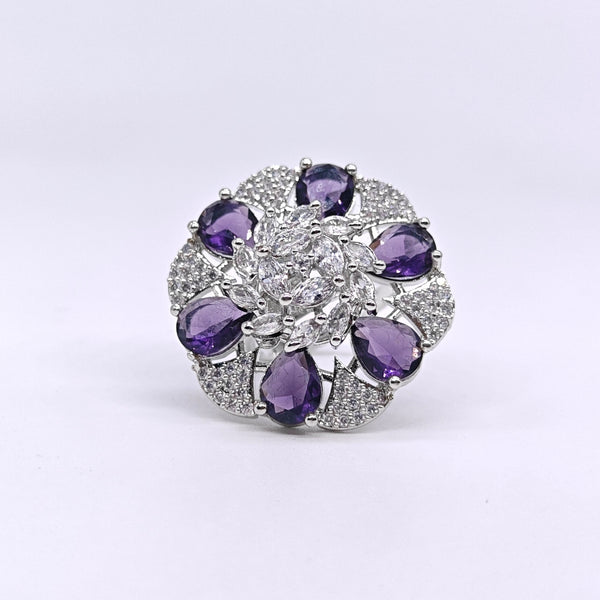 Jewelry ring with purple gemstones and clear stones on a white background