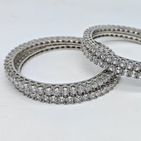 Two silver rings with diamond-studded bands on a white background