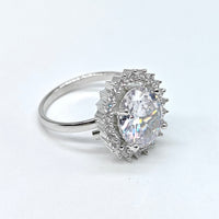 Silver ring with a large diamond and smaller diamonds on a white background