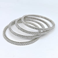 Set of silver bangles on a white background