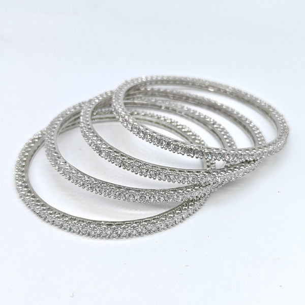 Set of silver bangles on a white background