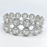 Silver ring with emerald-cut gemstones on a white background