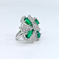 Silver ring with green gemstones on a white background