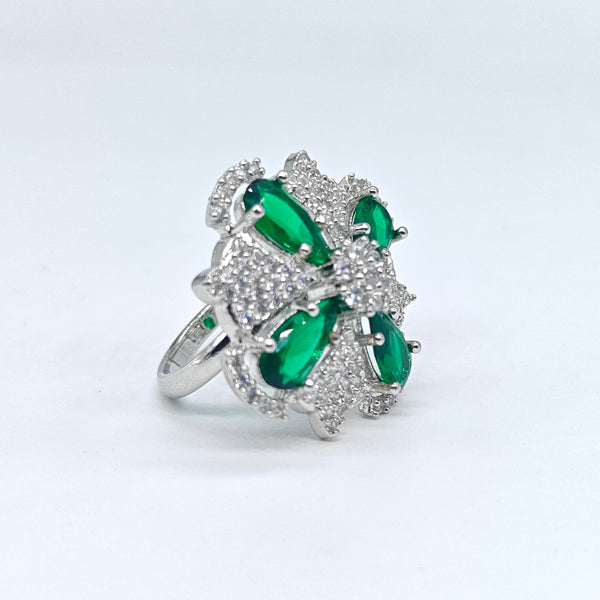 Silver ring with green gemstones on a white background