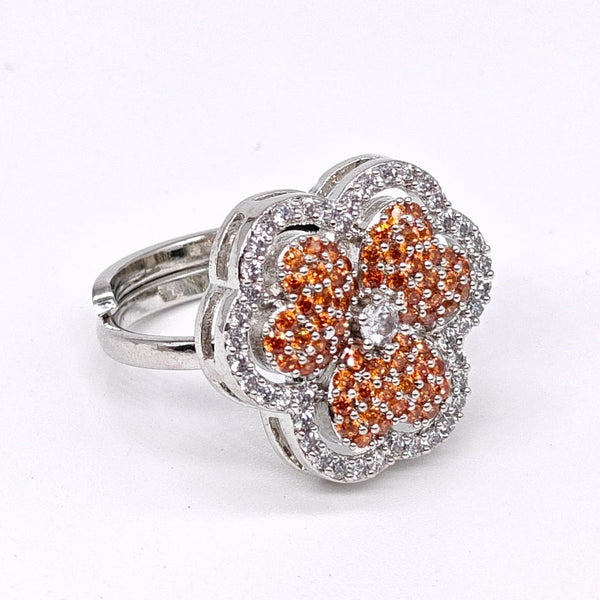 Silver ring with orange gemstones on a white background