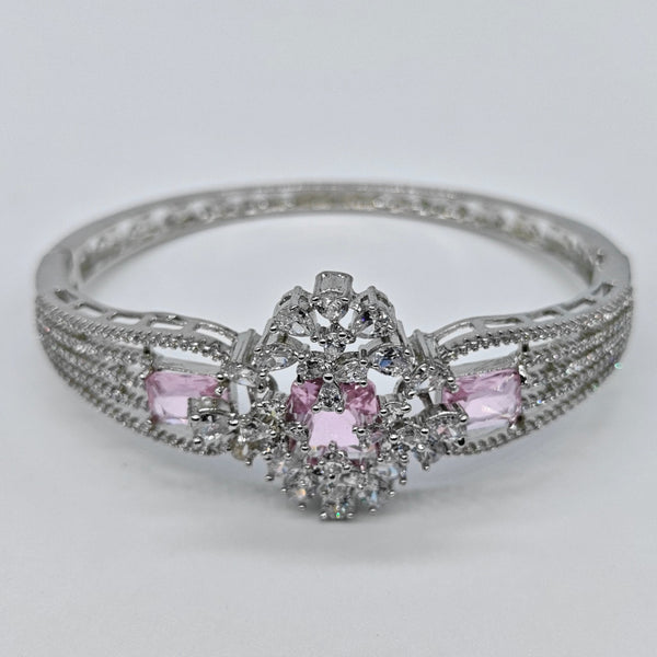 Silver ring with pink gemstones on a light gray background