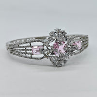 Silver ring with pink gemstone and diamond accents on a light gray background