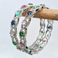 Silver bracelet with colorful gemstones on a wooden stick against a light background