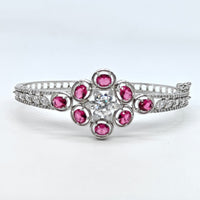 Silver ring with pink gemstones on a white background