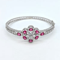 Silver bracelet with pink gemstones on a white background