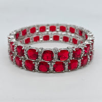 Red gemstone bracelet with silver accents on a white background