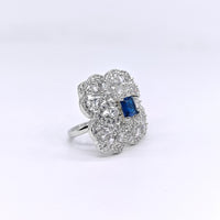 Diamond ring with a blue gemstone on a white background