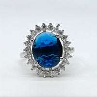Silver ring with a blue gemstone on a white background