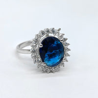 Silver ring with a blue gemstone on a white background