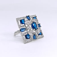 Ring with blue gemstones and clear stones on a white background