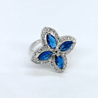 Butterfly-shaped ring with blue gemstones on a white background