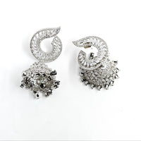 Pair of silver earrings with intricate designs on a white background