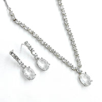 Silver necklace and earrings set on a white background