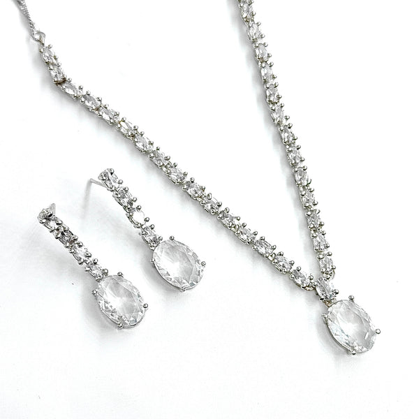 Silver necklace and earrings set on a white background