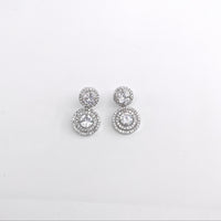 Pair of silver earrings with clear stones on a light gray background