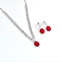 Jewelry set with red gemstones and silver accents on a white background