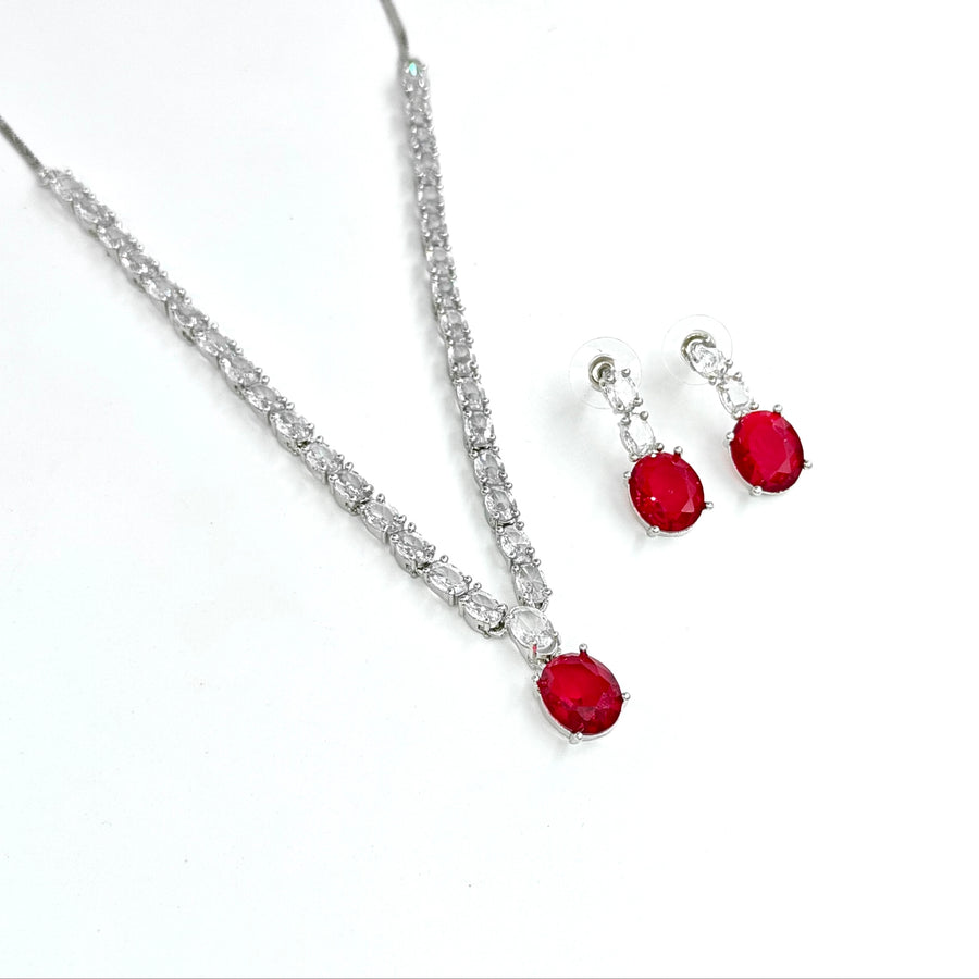 Jewelry set with red gemstones and silver accents on a white background