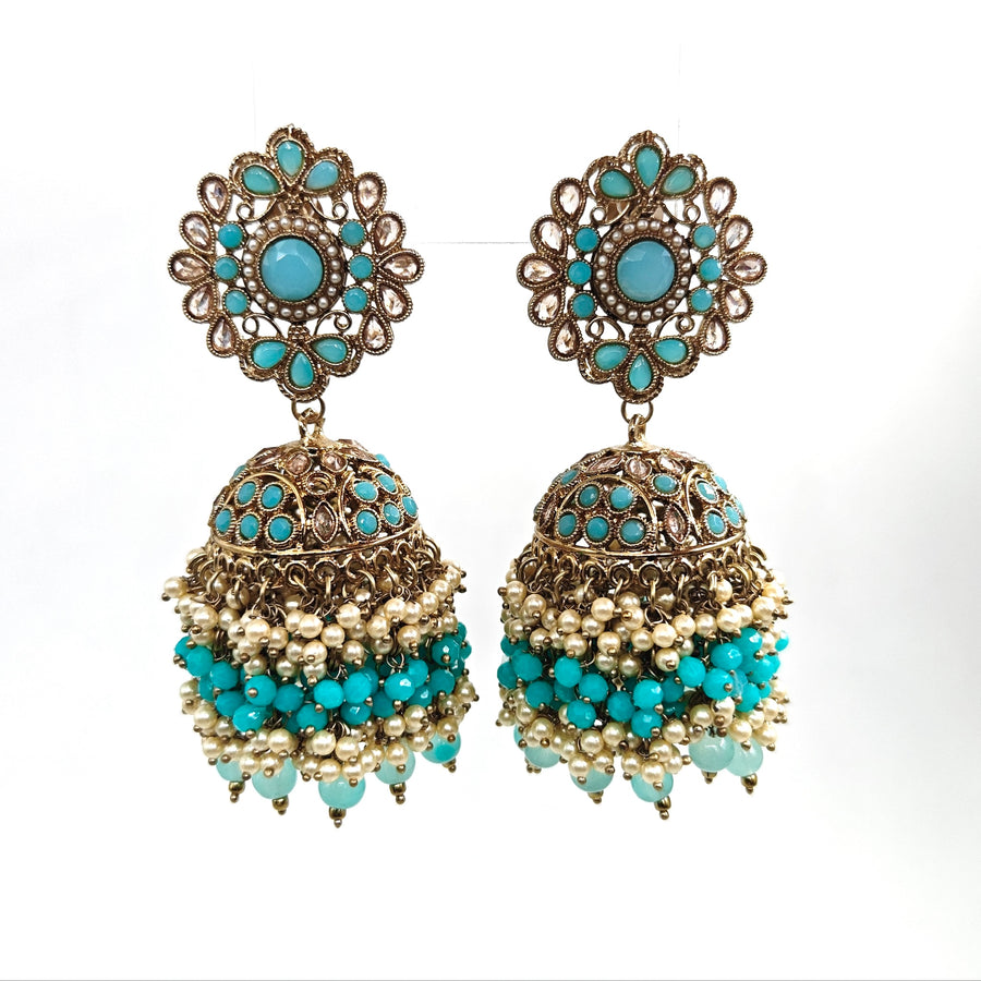 Pair of ornate earrings with turquoise stones and pearl-like beads on a white background