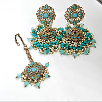 Ornate jewelry set with turquoise stones on a white background