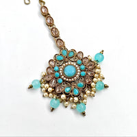 Decorative necklace with turquoise stones and pearl-like beads on a white background