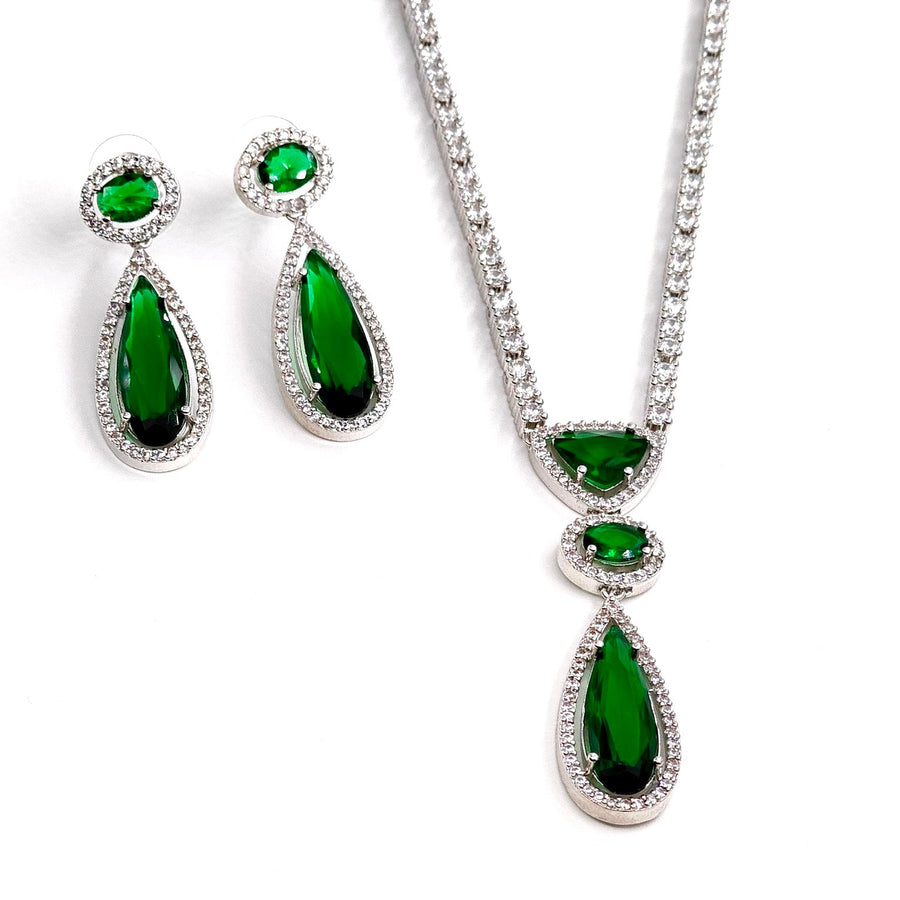 Jewelry set with green gemstones on a white background