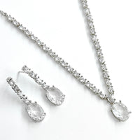 Silver necklace and earrings set on a white background