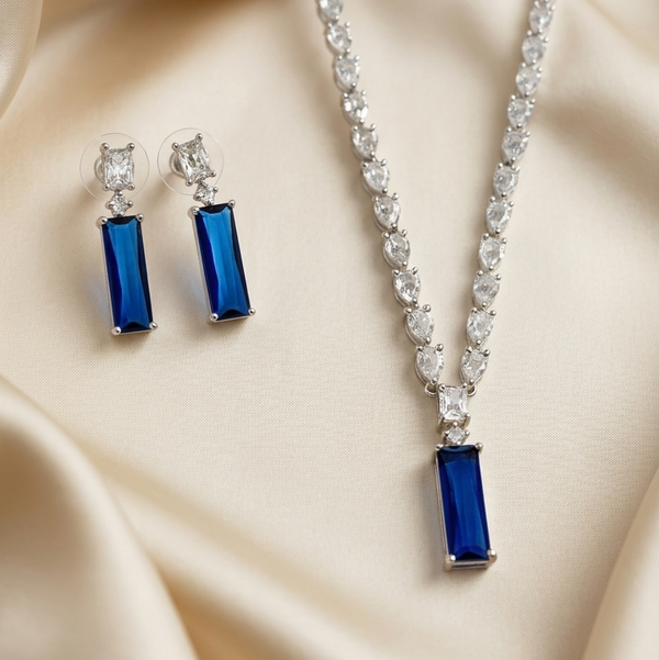 Jewelry set with blue rectangular stones on a beige fabric background